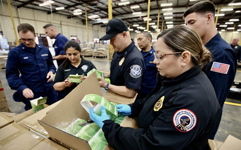 CBP and FDA officers inspect seized vape products during Operation Red Mist