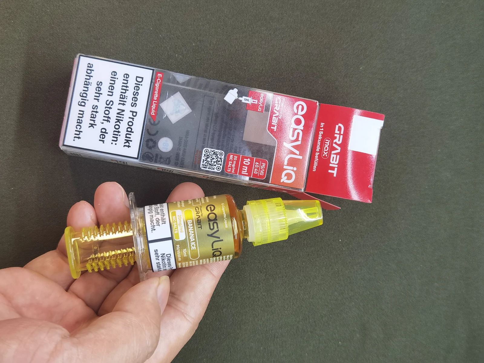 Editor hands-on photo of a GRABIT easyLiQ injector bottle beside the MAX packaging